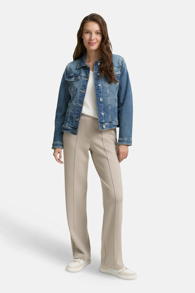 Beige joggingbroek van Tom Tailor, gedragen met een spijkerjasje en sneakers.