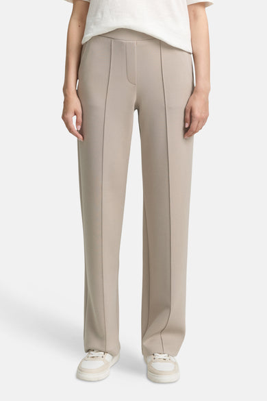 Beige joggingbroek van Tom Tailor met decoratieve stiksels en witte sportschoenen.