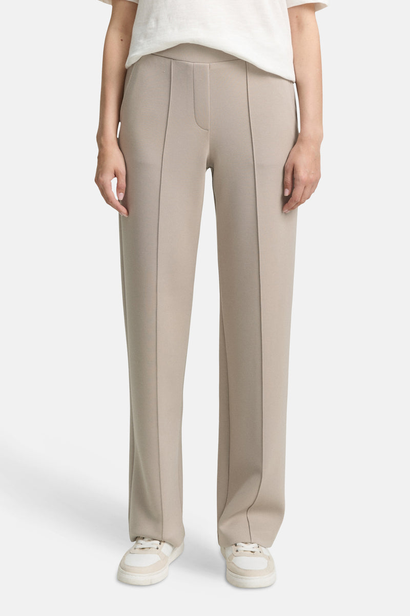 Beige joggingbroek van Tom Tailor met decoratieve stiksels en witte sportschoenen.