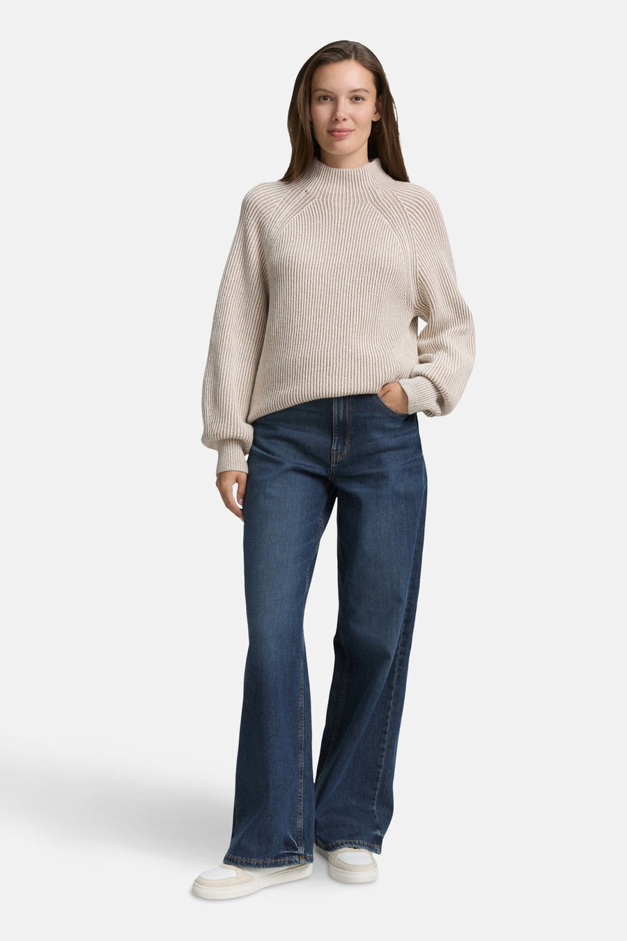 Pull beige côtelé de Tom Tailor, porté avec un jean bootcut bleu foncé et des baskets blanches.