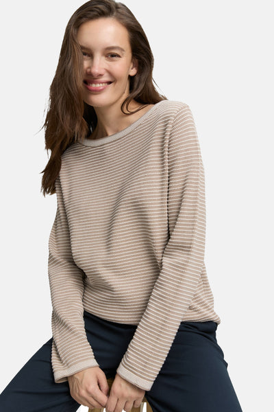 Pull à col rond beige de Tom Tailor avec motif texturé à rayures horizontales, porté avec un pantalon bleu marine.
