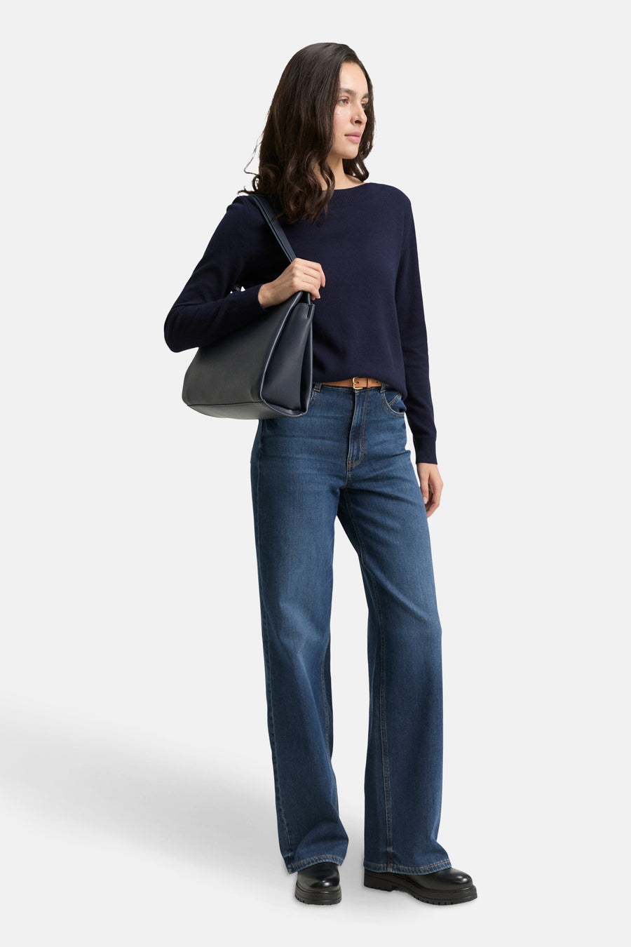 Pull bleu de Tom Tailor, porté avec un jean taille haute et un sac à main noir.
