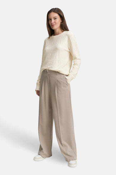 Witte Tom Tailor pull met reliëfpatroon en een relaxte pasvorm, gedragen met een beige broek.