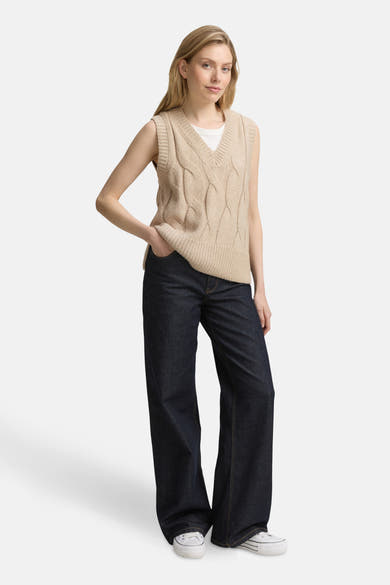 Beige mouliné tanktop van Tom Tailor, gedragen over een wit T-shirt met een wijde donkere jeans en witte sneakers.