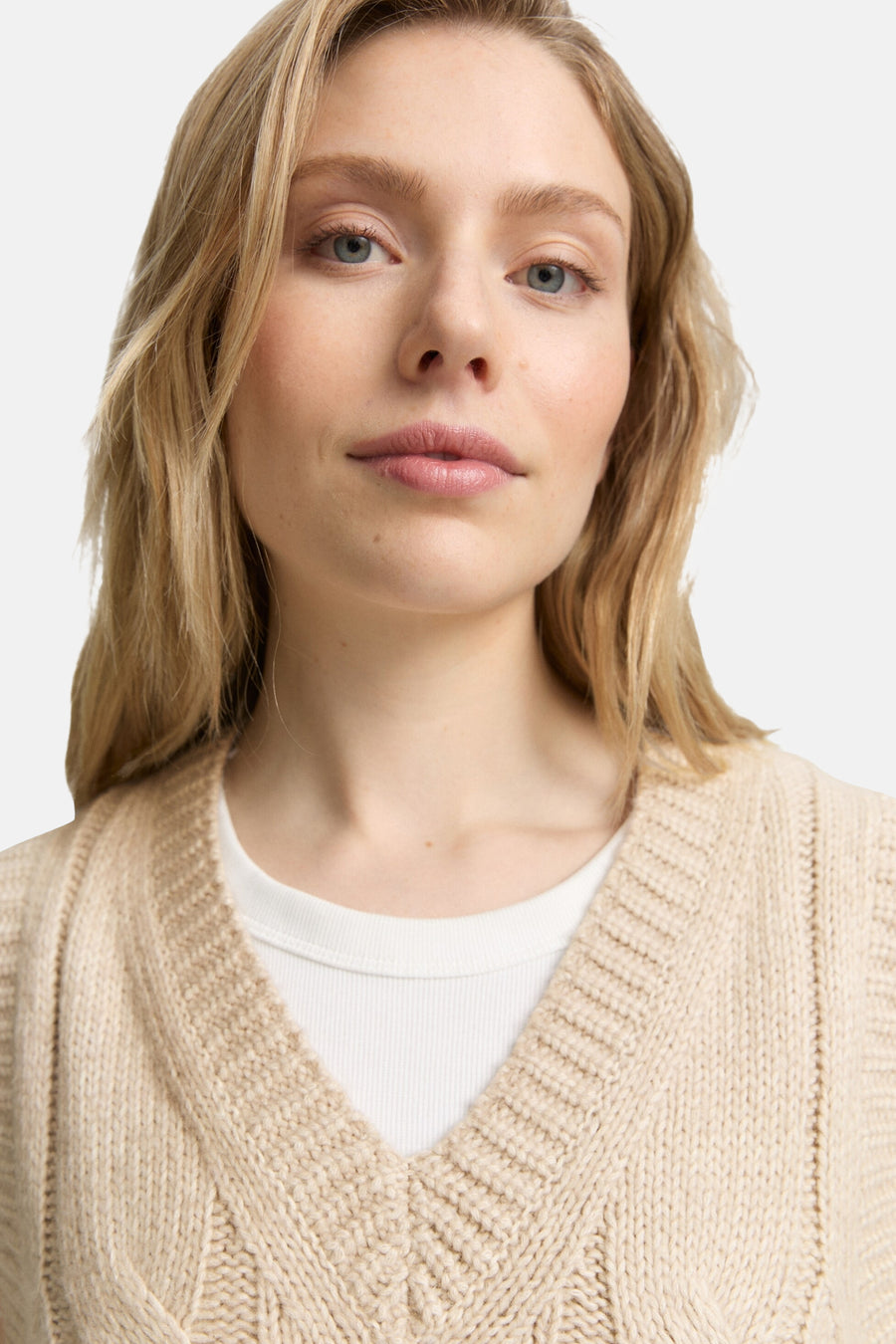 Beige Tom Tailor hemdje gedragen onder een kabelgebreid vest.