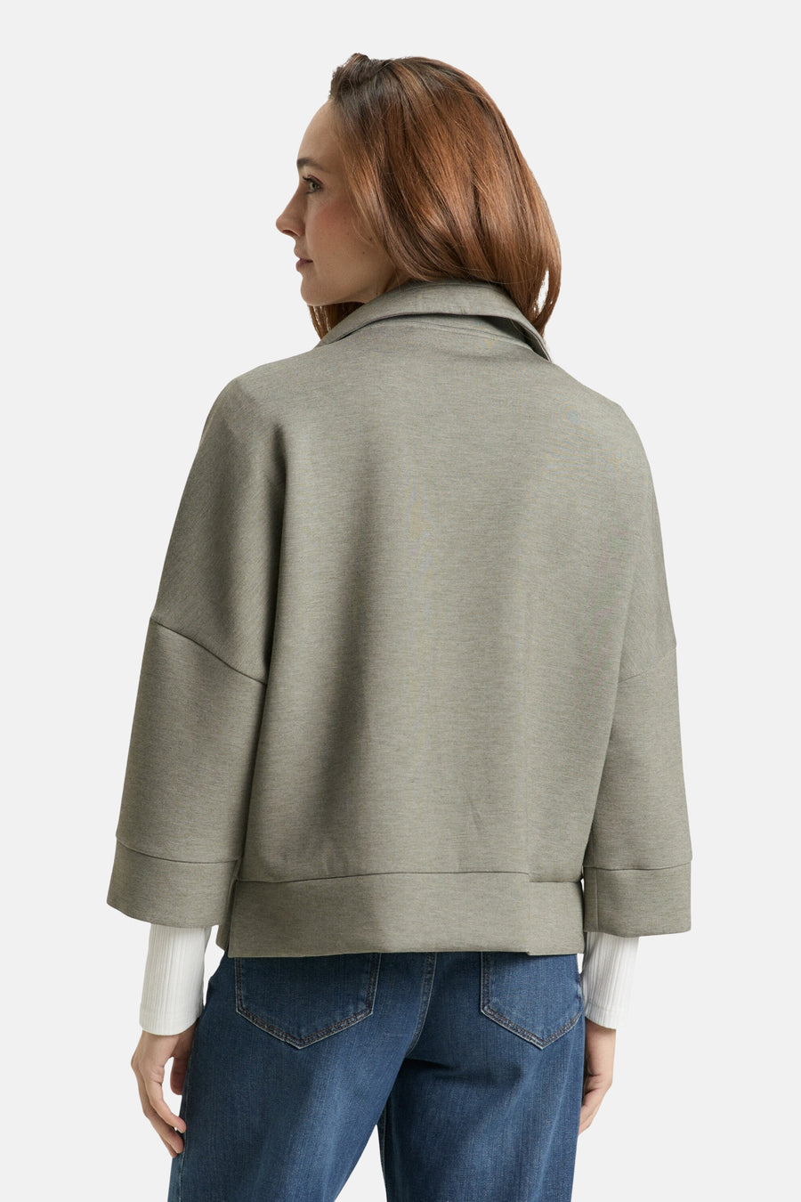 Cardigan kaki de Tom Tailor, avec des manches trois-quarts et porté avec un jean bleu.
