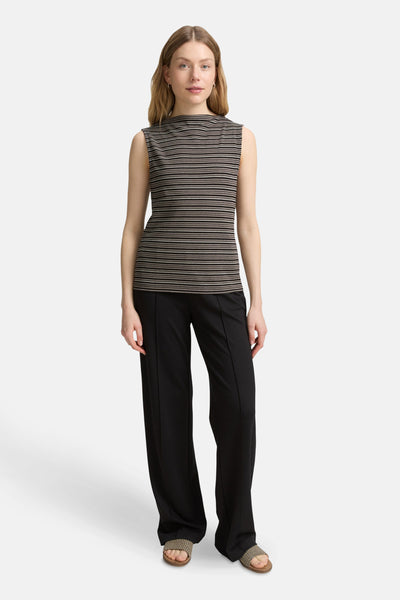 Multikleurig mouwloos topje van Tom Tailor, met horizontale strepen, gedragen met een wijde zwarte broek en sandalen.