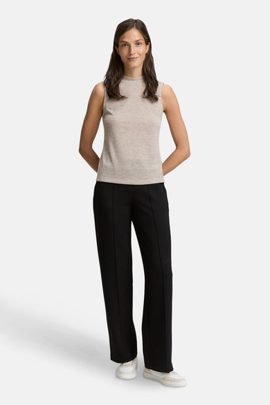 Beige mouwloze top van Tom Tailor, gedragen met een wijde zwarte broek en witte sneakers.