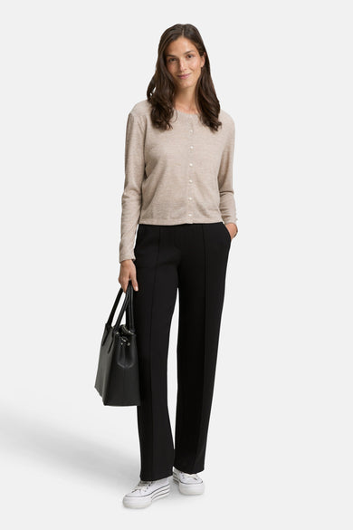 Beige cardigan van Tom Tailor, gedragen met een zwarte broek en witte sneakers.