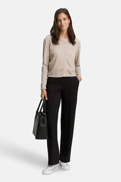 Beige cardigan van Tom Tailor, gedragen met een zwarte broek en witte sneakers.