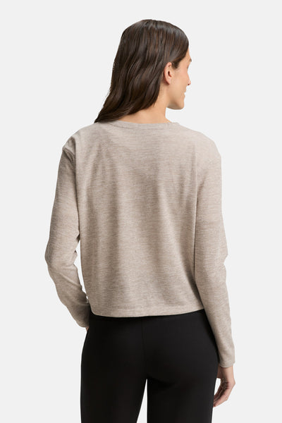 Beige gebreid vest van Tom Tailor, gedragen met een zwarte broek, achtergezicht.