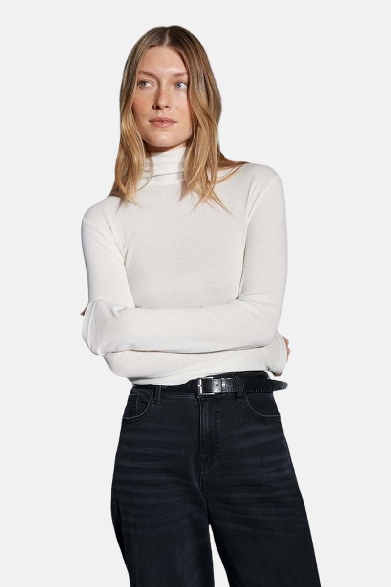 T-shirt à manches longues écru de OPUS, porté avec un jean noir taille haute et une ceinture en cuir.