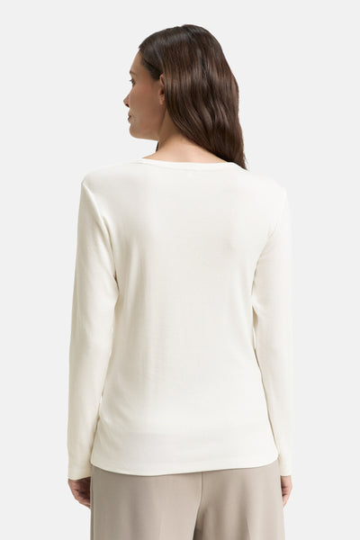 Witte T-shirt met lange mouwen van Tom Tailor, van achteren gezien, gedragen met een beige broek.