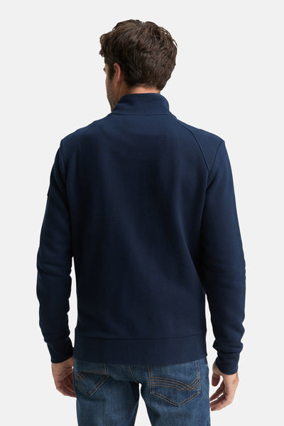 Blauwe Tom Tailor sweatvest met rits, opstaande kraag en lange mouwen, gedragen met een spijkerbroek.