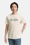 Wit T-shirt met korte mouwen van Tom Tailor, met opdruk op de voorkant en gedragen met een blauwe jeans.