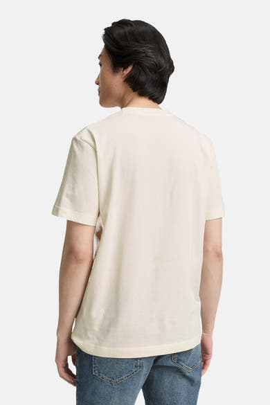 Witte T-shirt met korte mouwen van Tom Tailor, gedragen met een spijkerbroek, achtergezicht.