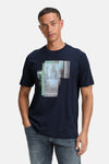 Blauw T-shirt met korte mouwen van Tom Tailor, met abstracte grafische print op de voorkant, gedragen met een spijkerbroek.