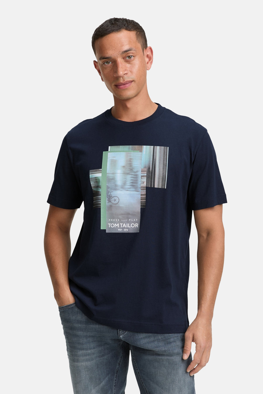 Blauw T-shirt met korte mouwen van Tom Tailor, met abstracte grafische print op de voorkant, gedragen met een spijkerbroek.