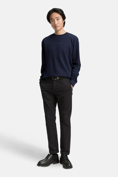 Ronde hals trui blauw van Tom Tailor, gedragen met een zwarte broek en leren schoenen.