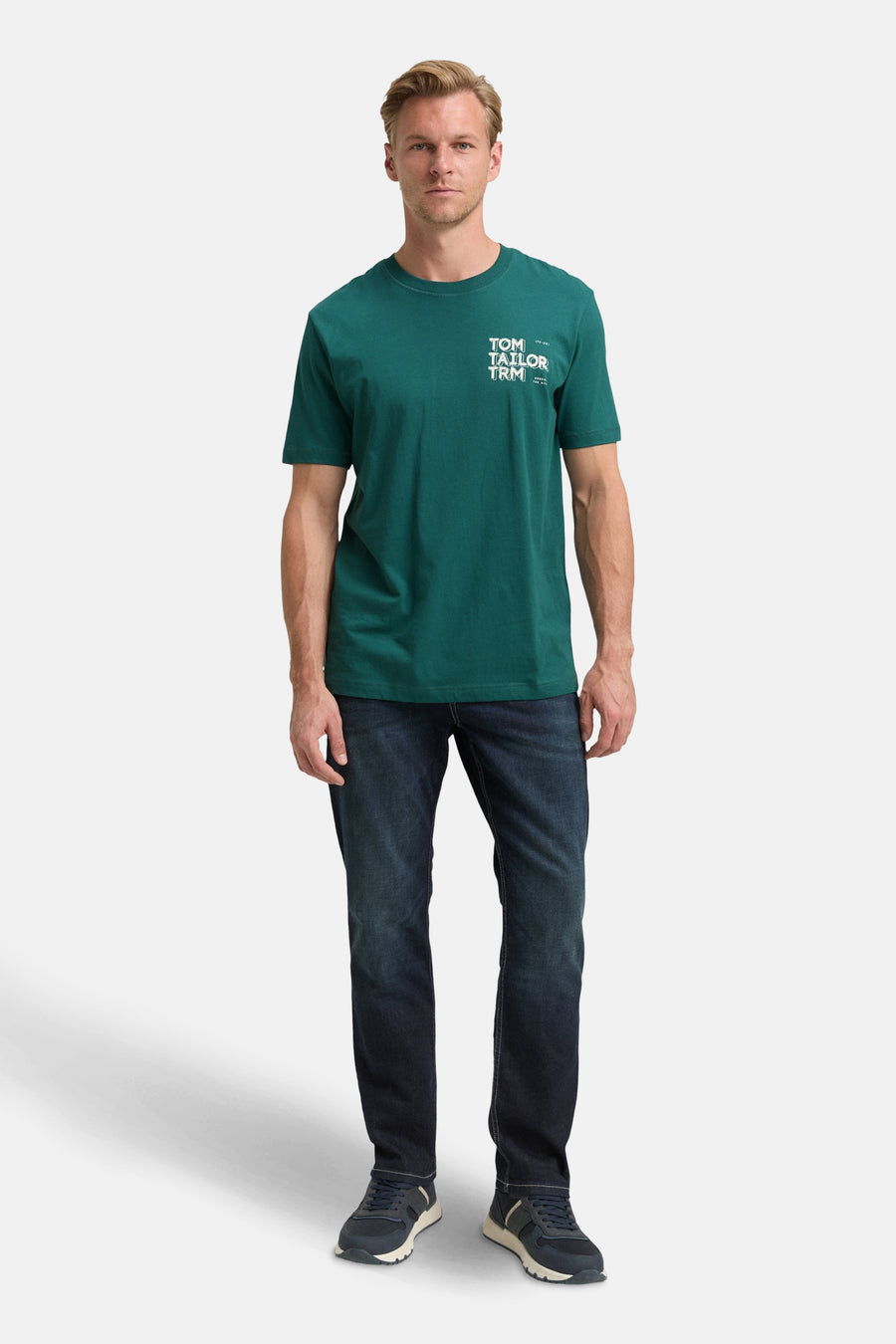 Groen T-shirt met korte mouwen van Tom Tailor, gedragen met een blauwe jeans en bijpassende sneakers.