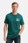 Groen T-shirt met korte mouwen van Tom Tailor, gedragen met een spijkerbroek, man met een hand in zijn zak.