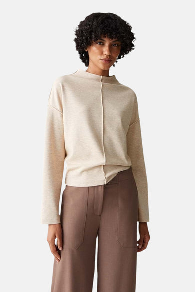 Beige ronde hals trui van OPUS, gedragen met een bruine broek met hoge taille en zwarte loafers.