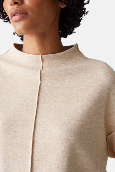 Pull à col rond beige de OPUS, avec une couture verticale visible et un col montant discret.
