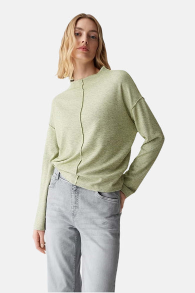 Pull à col rond vert par OPUS, avec couture centrale verticale et porté avec un jean gris.