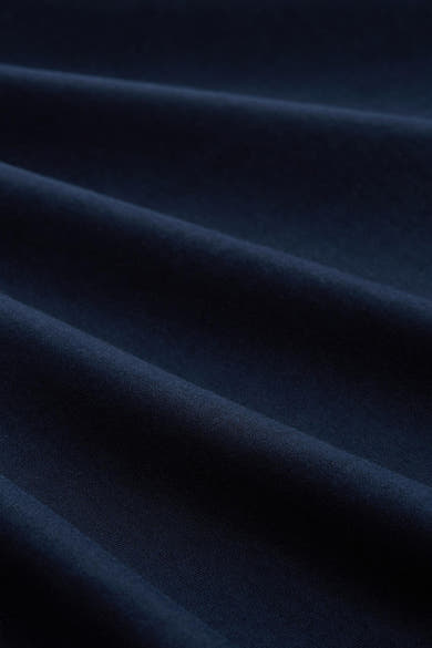 Donkerblauwe jas van Tom Tailor, getextureerde stof met zachte plooien en subtiele glans.