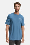 Blauw T-shirt met korte mouwen van Tom Tailor, met een opdruk op de voorkant en een man die een grijze broek draagt.