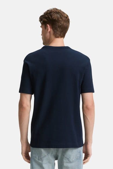 Blauw T-shirt met korte mouwen van Tom Tailor, van achteren gezien, gedragen met een spijkerbroek.