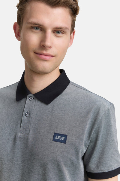 Polo bleu à manches courtes de Tom Tailor, avec col noir et détail logo sur le côté.