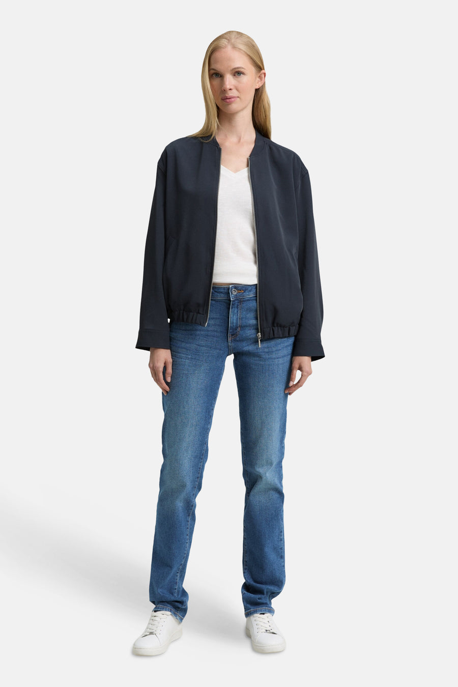 Jean droit bleu moyen de Tom Tailor, porté avec une veste style bombardier bleu marine et un t-shirt blanc uni.