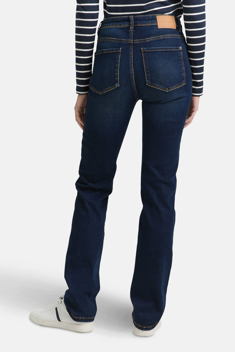 Jean droit en denim bleu foncé de Tom Tailor, coupe classique, porté avec un haut rayé bleu et blanc.