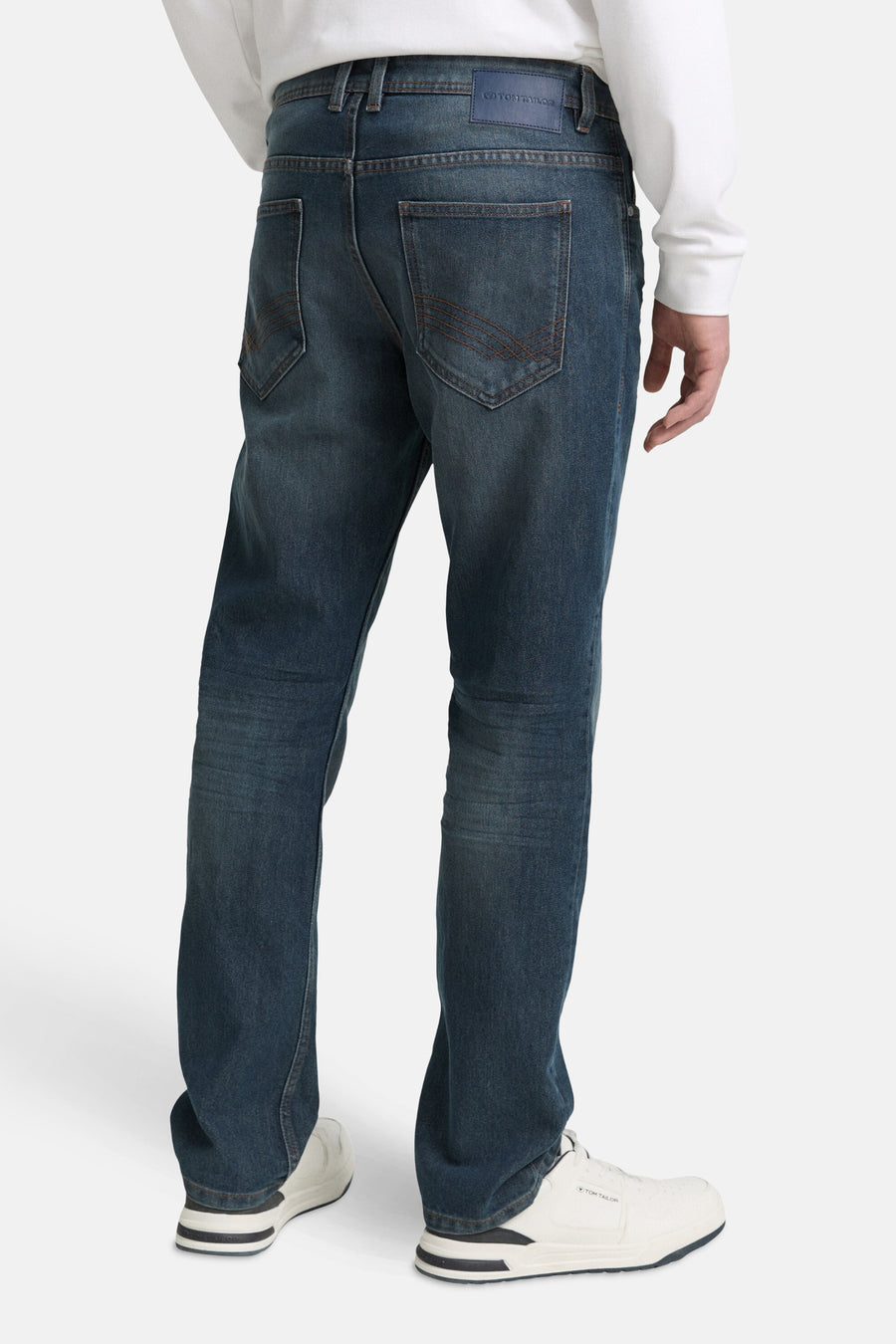 Rechte blauwe denim jeans van Tom Tailor, met gestikte achterzakken, gedragen met een witte trui en witte sneakers.
