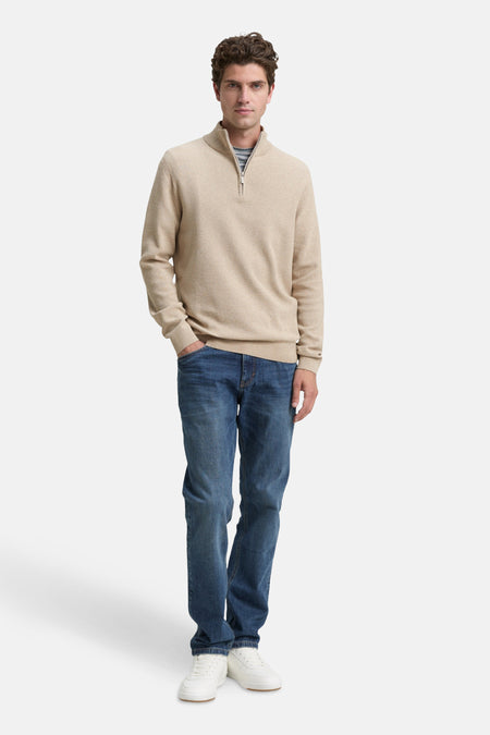 Beige ronde hals trui van Tom Tailor, gedragen met een blauwe jeans en witte sneakers.
