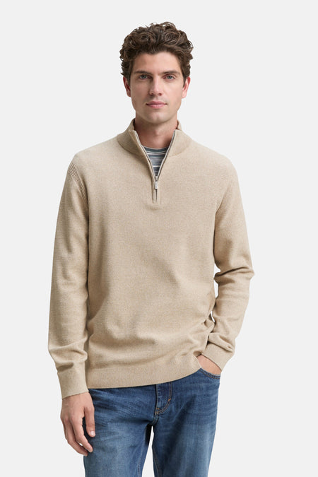 Beige ronde hals trui van Tom Tailor, met ritssluiting en gedragen over een grijs gestreept T-shirt en een blauwe jeans.
