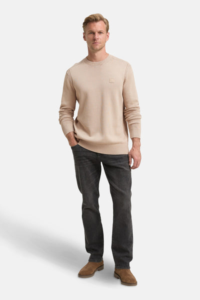 Beige ronde hals trui van Tom Tailor, gedragen met een donkergrijze jeans en bruine schoenen.