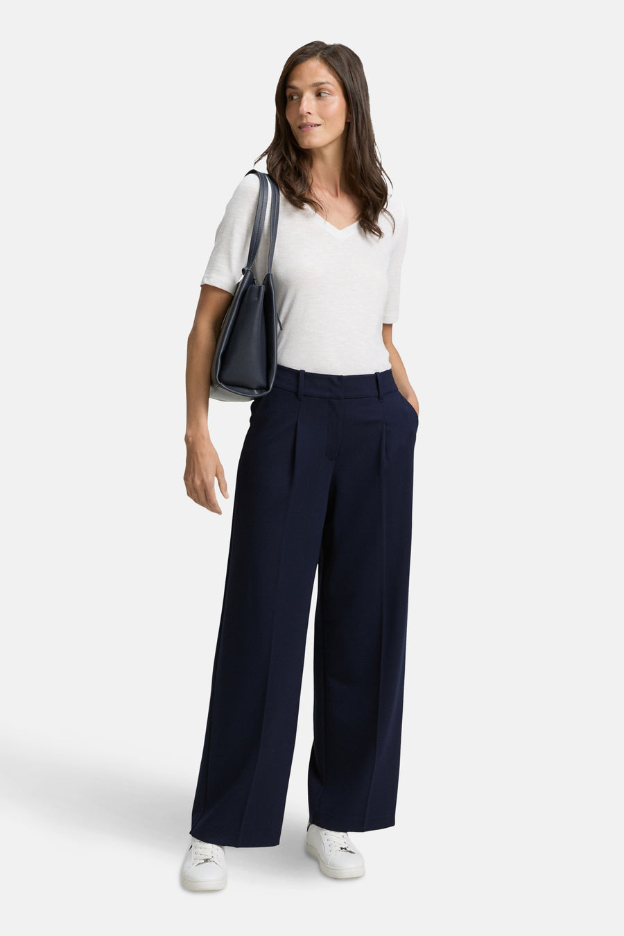 Blauwe pantalon van Tom Tailor, gedragen met een wit T-shirt en witte sneakers.