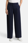 Blauwe Tom Tailor pantalon, wijde pasvorm met plooien en zijzakken, gedragen met witte sneakers.