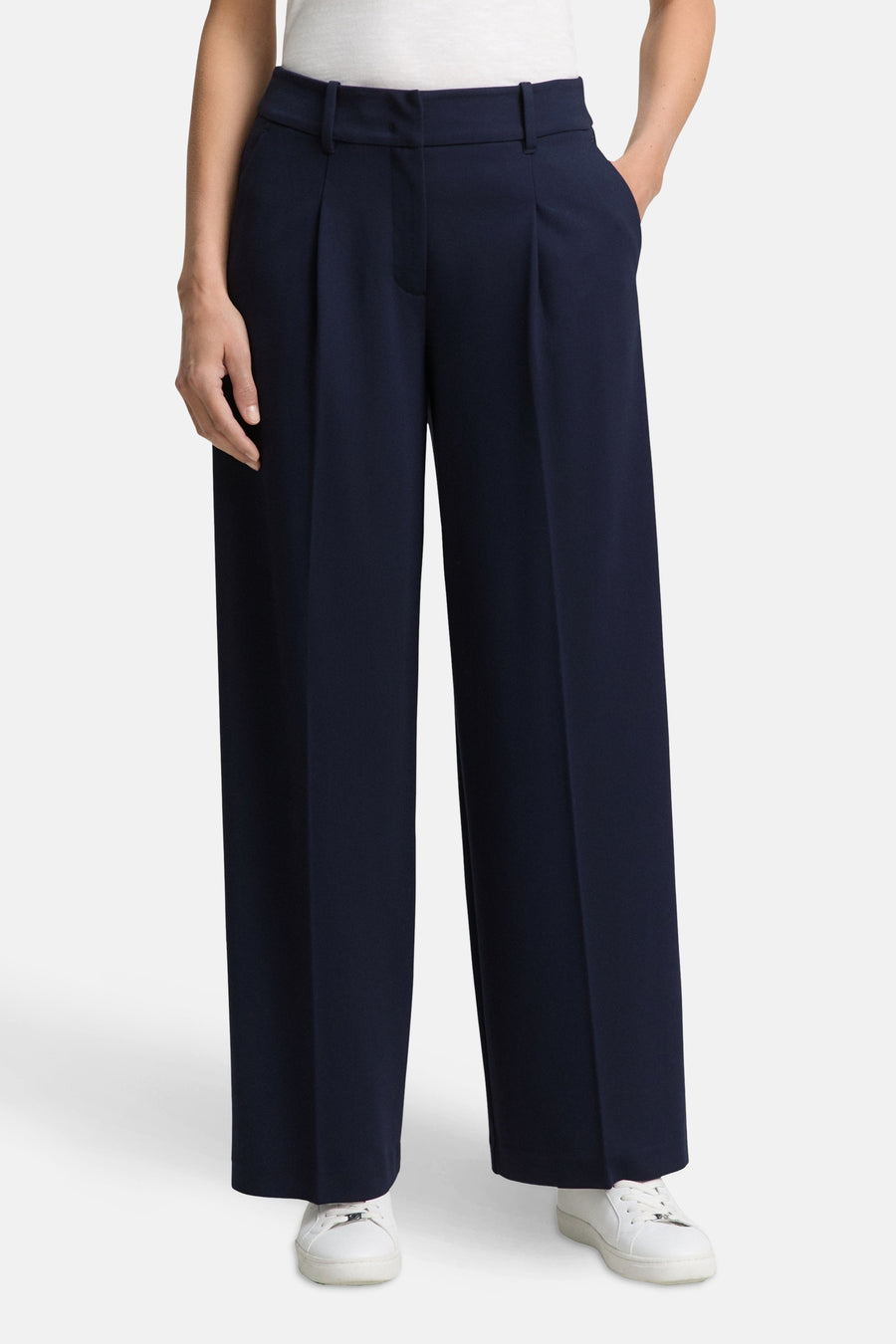 Blauwe Tom Tailor pantalon, wijde pasvorm met plooien en zijzakken, gedragen met witte sneakers.