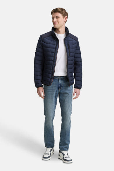 Veste courte bleue par Tom Tailor, avec fermeture éclair et poches, portée sur un t-shirt blanc et un jean décontracté.