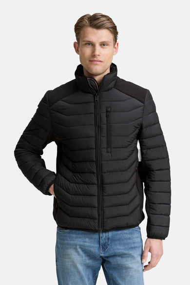 Veste courte noire de Tom Tailor, matelassée avec fermeture éclair, portée avec un jean bleu.