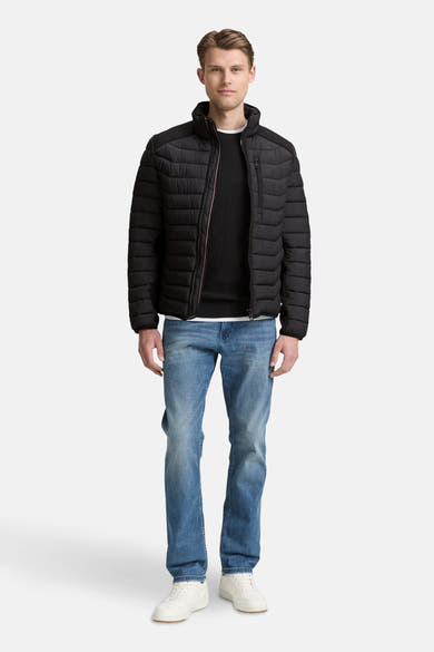 Veste courte noire de Tom Tailor, portée avec un pull noir, un jean bleu et des baskets blanches.