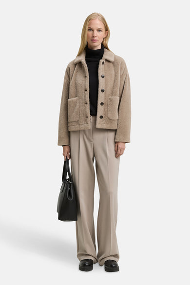 Veste courte beige en fausse fourrure de Tom Tailor, avec un col à revers et des poches plaquées.