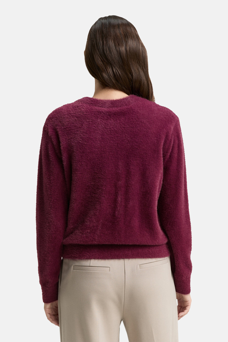 Rode, pluizige gebreide cardigan van Tom Tailor, van achteren getoond met een beige broek.