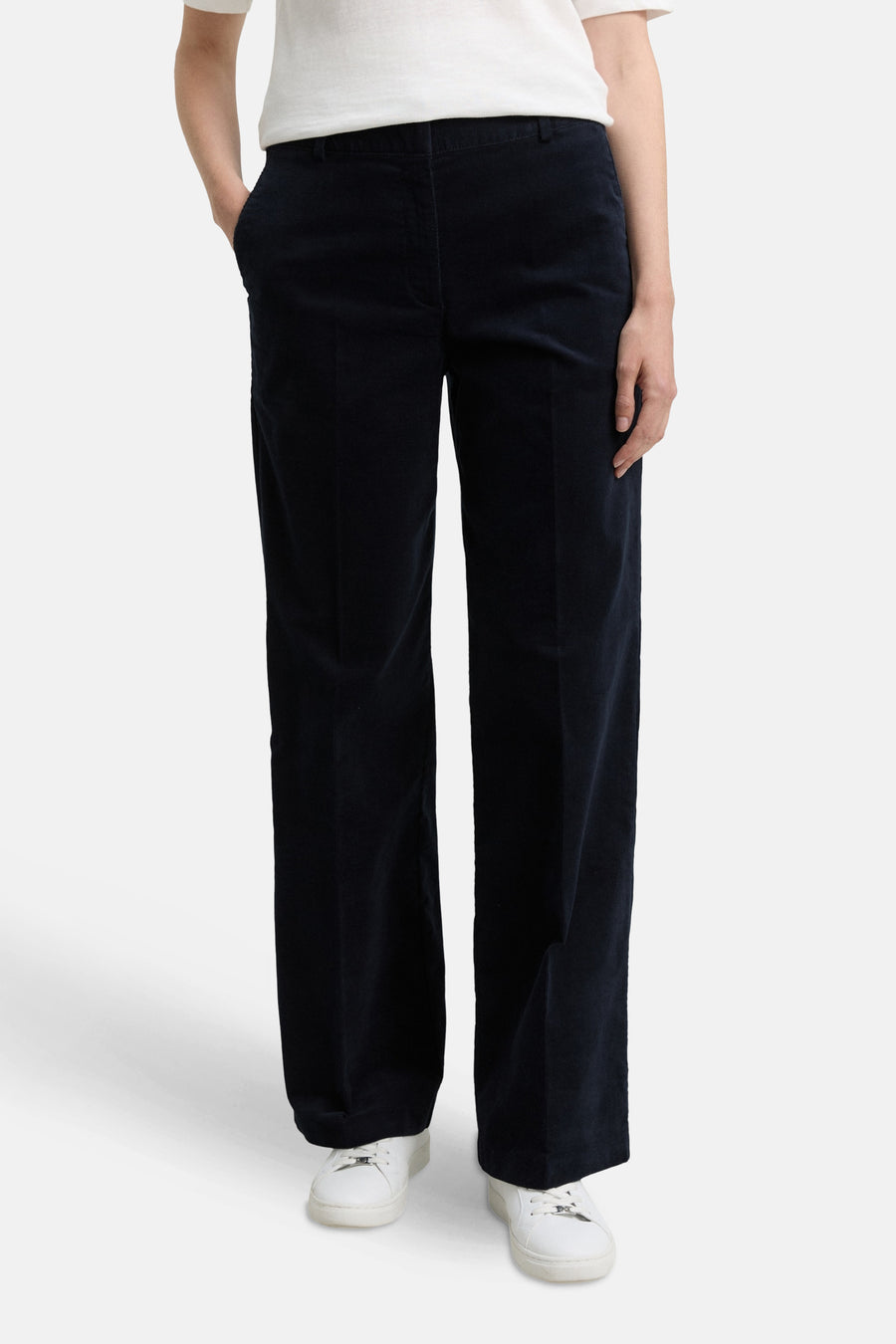 Blauwe corduroy broek van Tom Tailor, met zijzakken en witte sportschoenen.