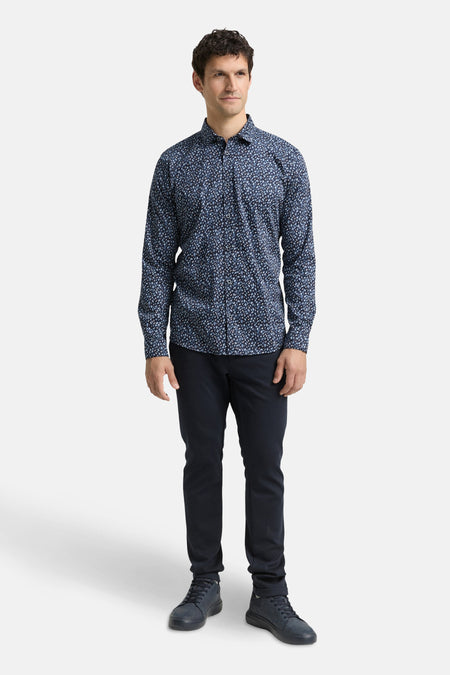 Chemise à manches longues bleue de Tom Tailor, à motifs floraux, portée avec un pantalon marine et des chaussures assorties.
