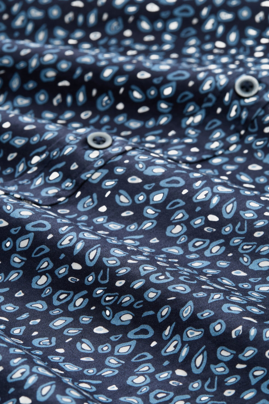Blauw overhemd met lange mouwen van Tom Tailor, blauw-wit gespikkeld patroon, zichtbare grijze knopen.