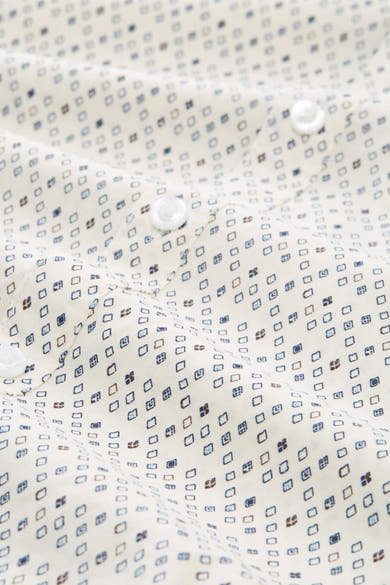 Chemise à manches longues blanche par Tom Tailor, à motifs losanges bleus et marron, avec boutons blancs.

